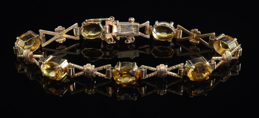 Gold bracelet set with seven faceted oval citrines joined by x links stamped marks, 9ct.Overall in