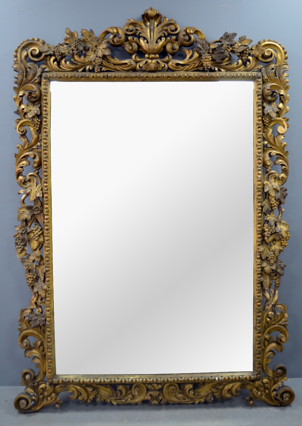 Late 18th /19th century carved wood gilt framed mirror decorated with Rococo forms, grapes and