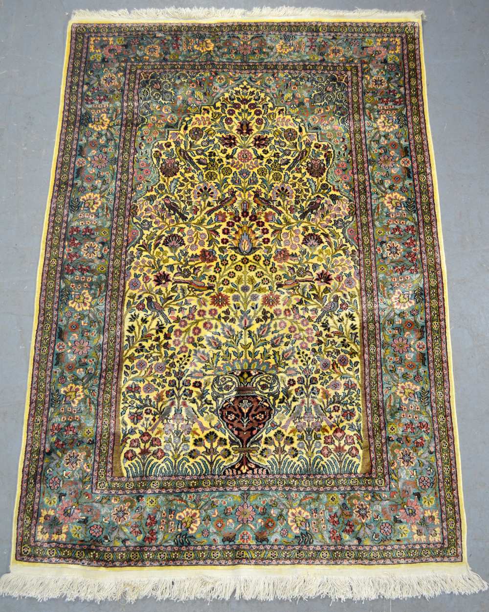 Silk Kashmir cream ground rug with a main green border centre decorated with foliate forms 72 x