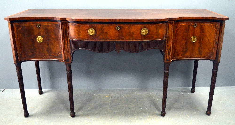 George III mahogany and crossbanded serpentine sideboard with centeral drawer flanked by two deep