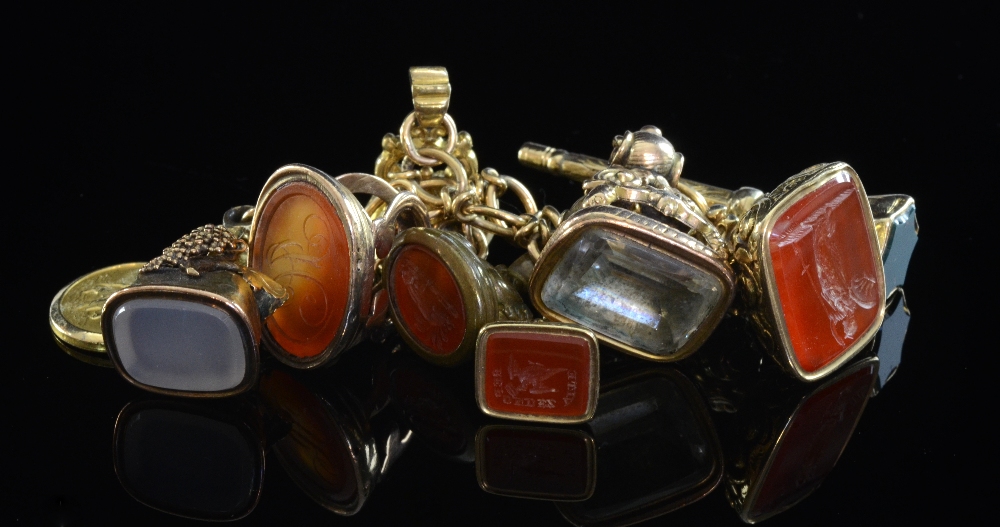 A Victorian fancy link chain bracelet with an intaglio cut cornelian set seal fob and six others