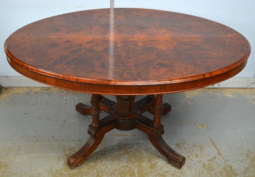 19th century walnut oval table on reeded turned supports to splayed legs, later stamped `Gillow`