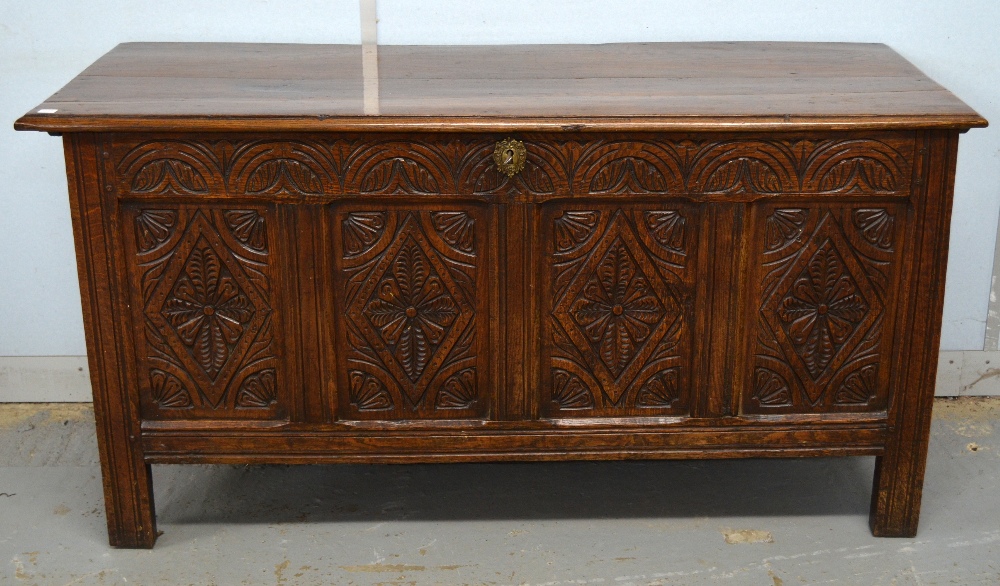 18th century oak coffer, the front with carved foliate decoration 28 x 55 x 21in. (71 x 140 x 53cm)