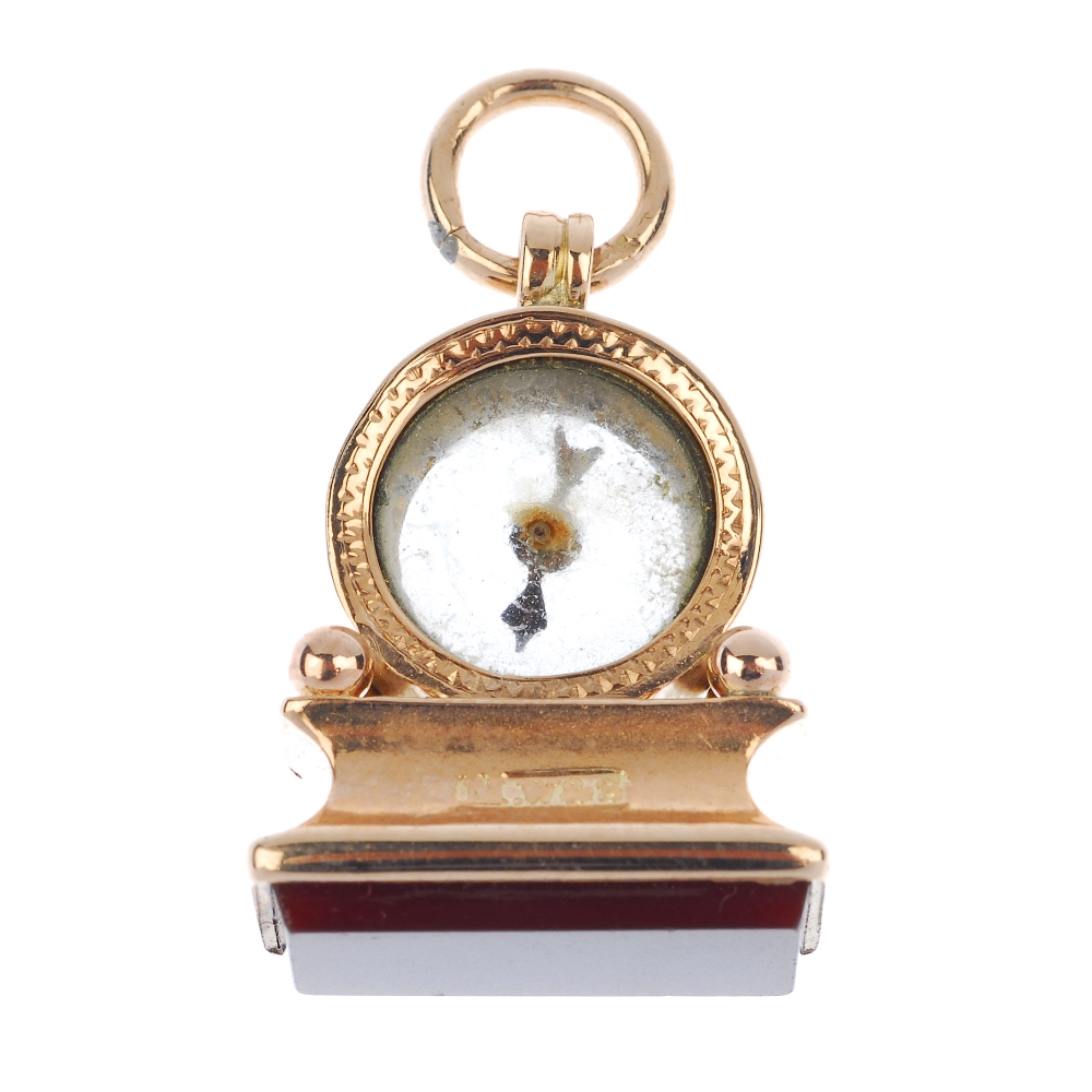 A late Victorian 9ct gold carnelian novelty compass fob. Modelled as a mantle clock, with compass `