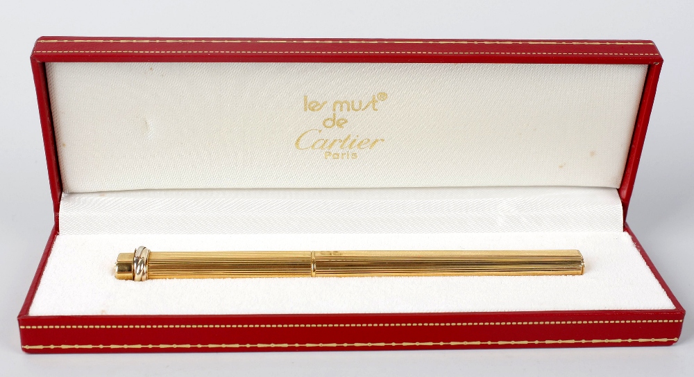 A Must de Cartier `Vendome` ballpoint pen, the gold plated case of ovoid rectangular form, within