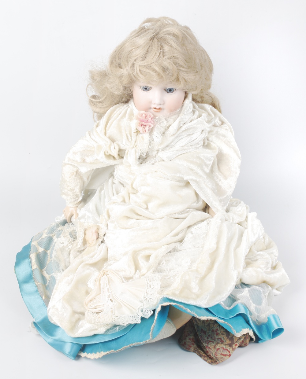An Armand Marseille bisque headed doll, modelled as a young girl with blonde hair, opening blue