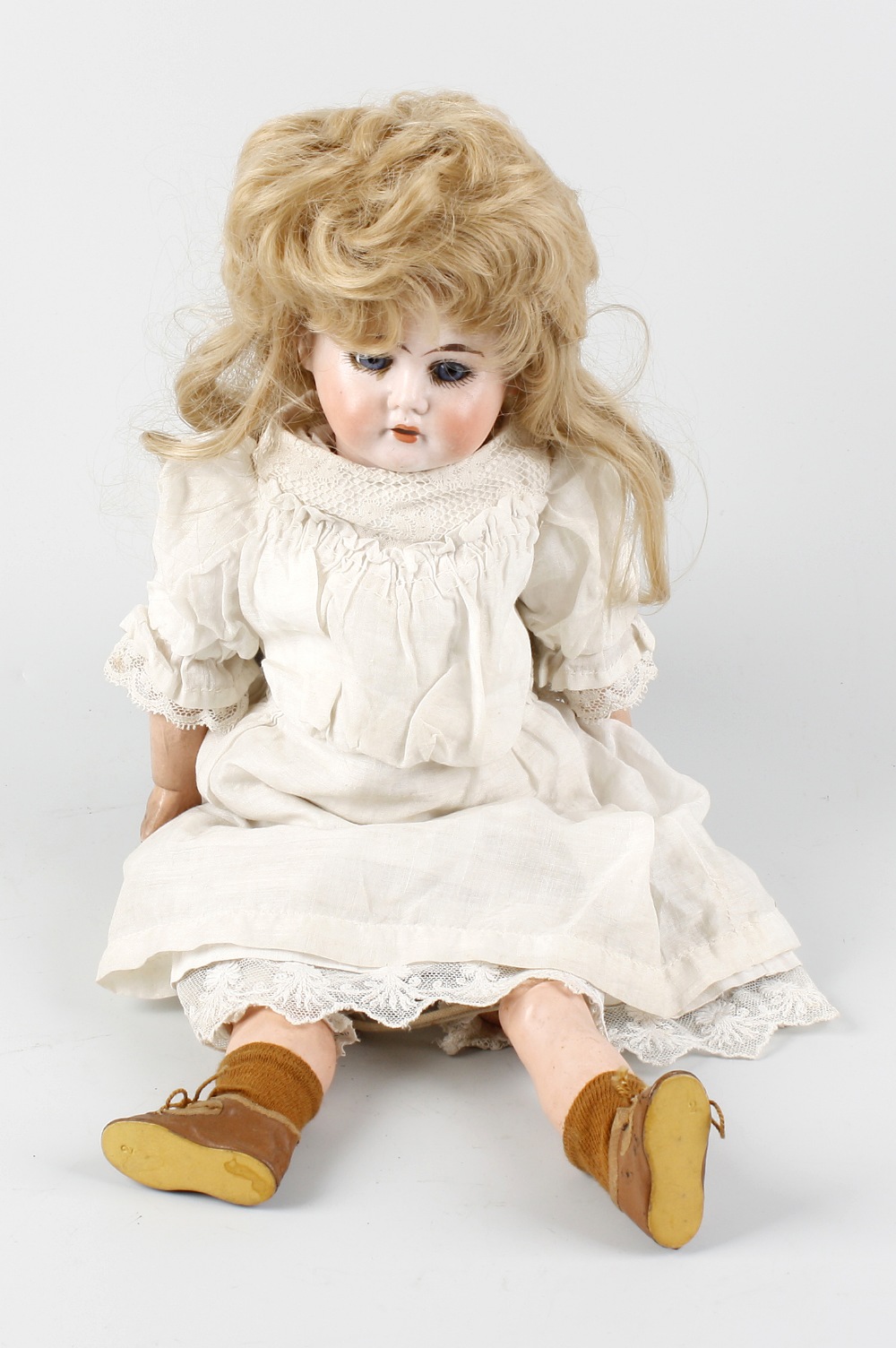 An early 20th century German bisque-headed porcelain doll, with long blonde hair, moving blue eyes,