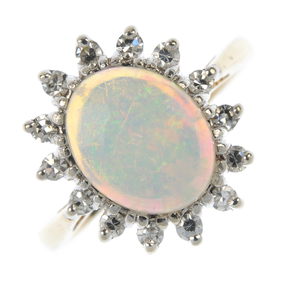 An opal and diamond cluster ring. The oval opal cabochon, within a single-cut diamond accent