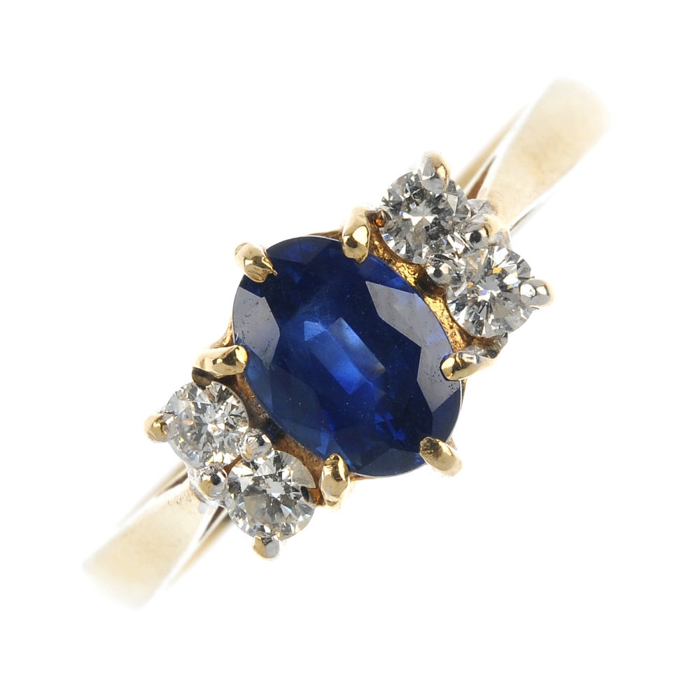 A 9ct gold sapphire and diamond ring. The oval-shape sapphire, with brilliant-cut diamond double