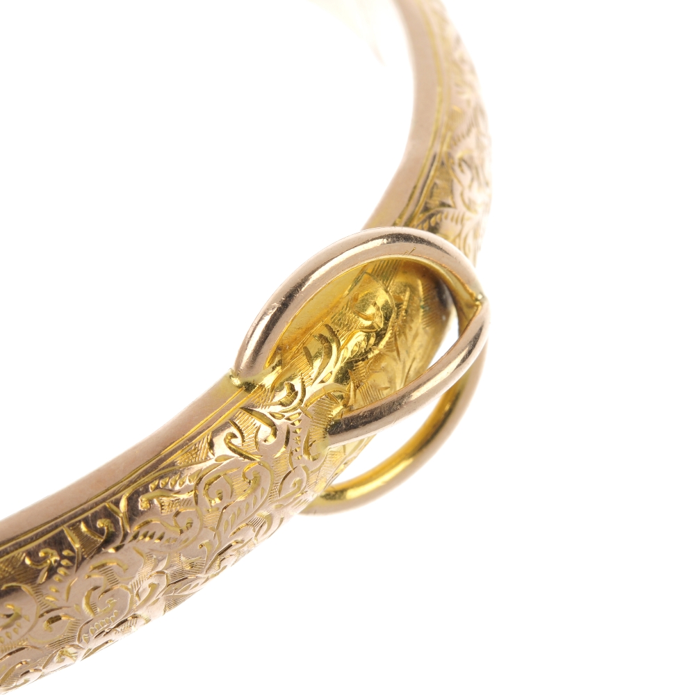 An Edwardian 9ct gold hinged bangle. The foliate engraved front panel, with stylised buckle, to the - Image 2 of 3