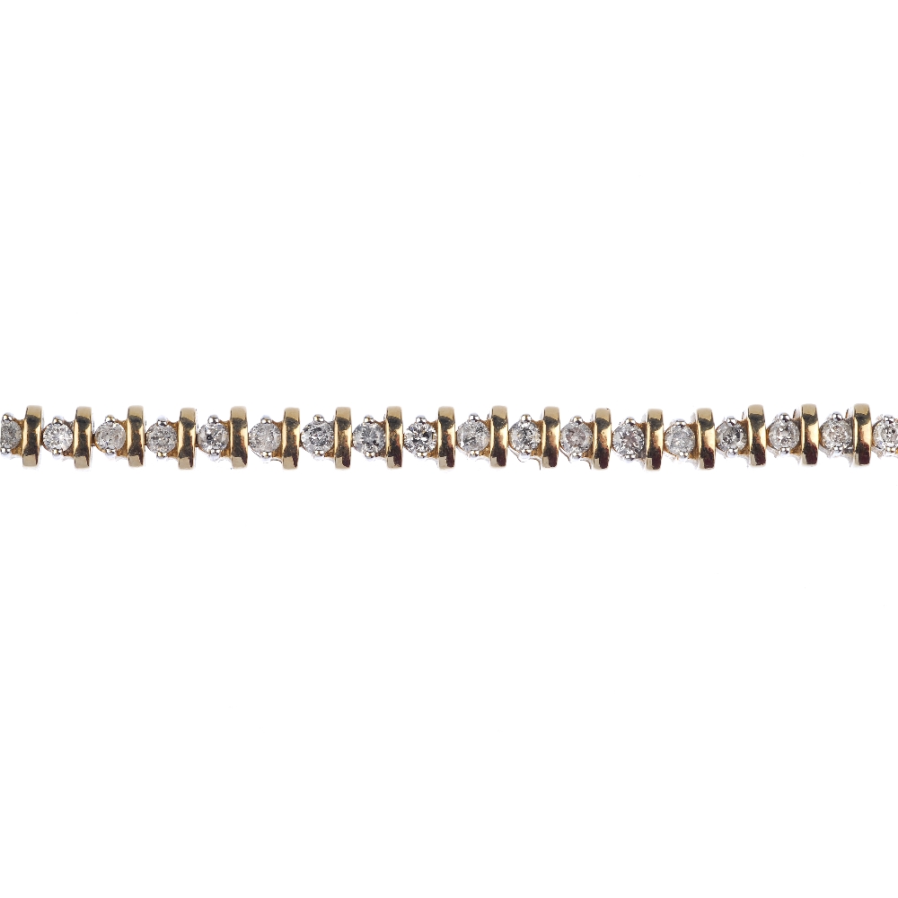 A 9ct gold diamond bracelet. The brilliant-cut diamond line, with bar spacers, to the partially