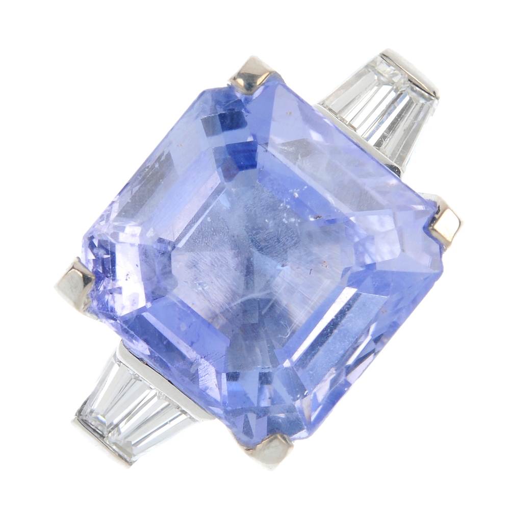 A sapphire and diamond ring. The square-shape sapphire, to the tapered baguette-cut diamond