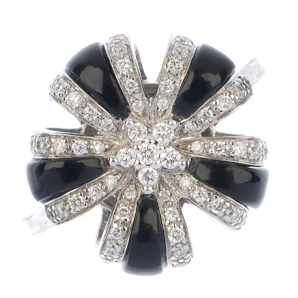 An 18ct gold diamond and onyx cluster ring. Of floral design, the brilliant-cut diamond and onyx