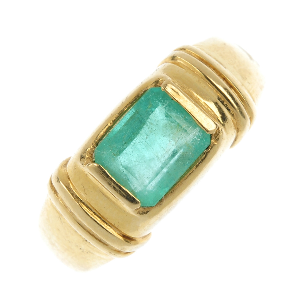 An emerald band ring. The rectangular-shape emerald collet, to the groove sides and tapered band.