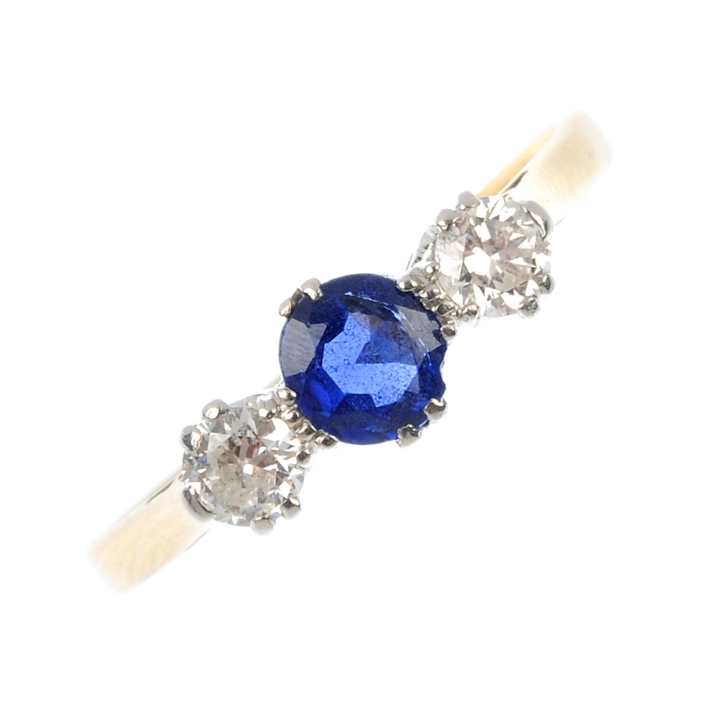 An early 20th century 18ct gold sapphire and diamond three-stone ring. The oval-shape sapphire, to