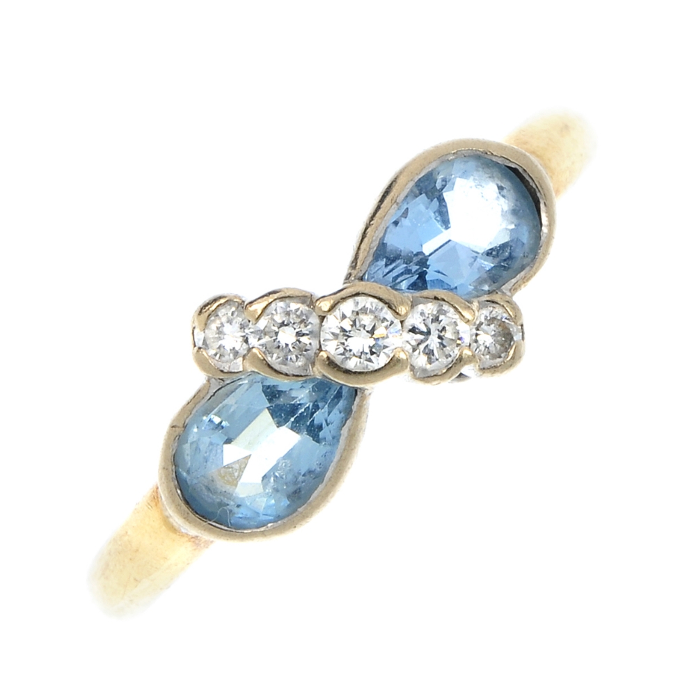 An 18ct gold aquamarine and diamond dress ring. The graduated brilliant-cut diamond diagonal line,