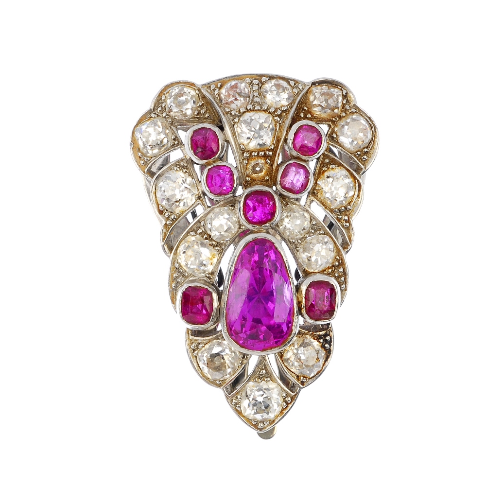 An early 20th century platinum and 18ct gold ruby and diamond clip. The pear-shape ruby, with
