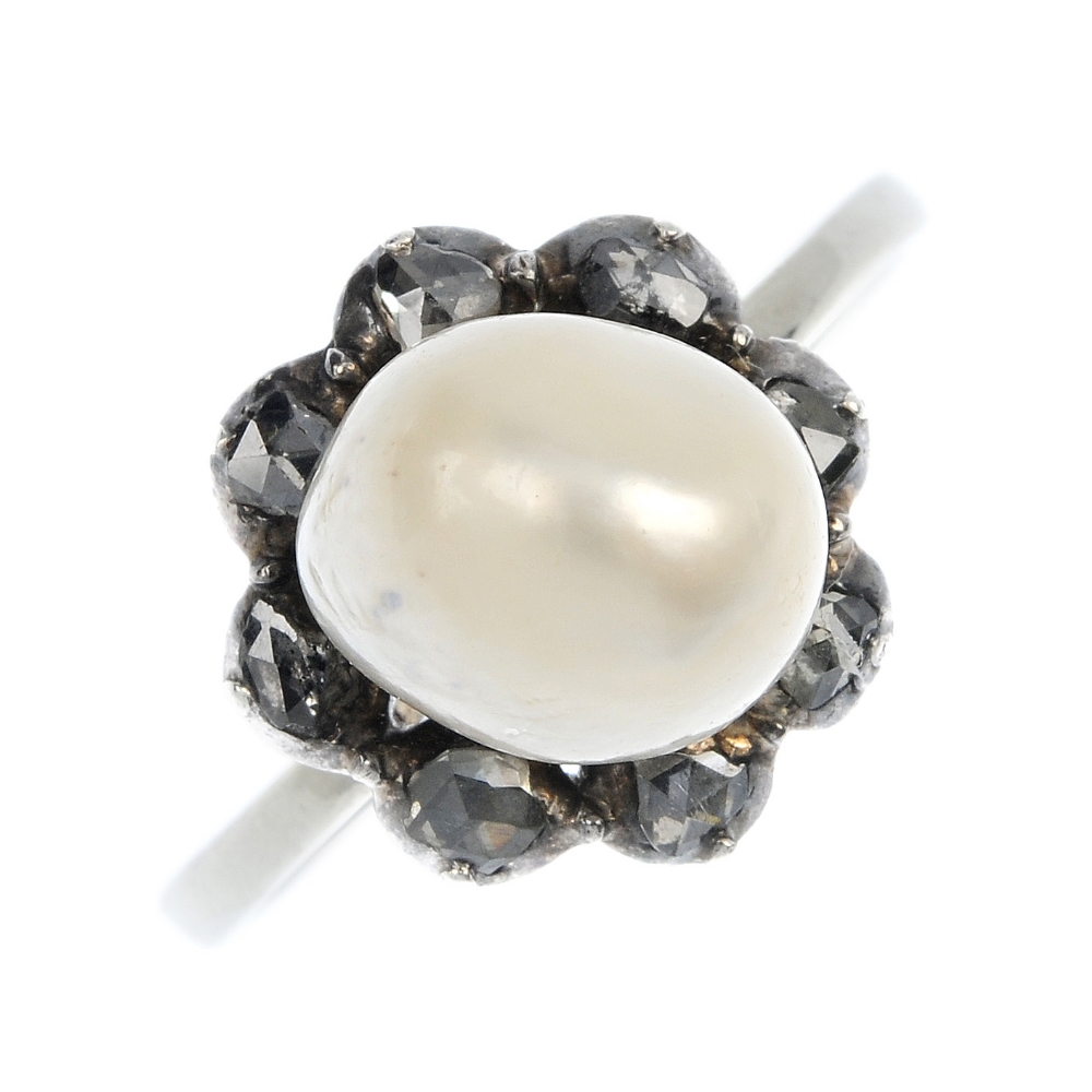 A cultured pearl and diamond cluster ring. The baroque cultured pearl within a rose-cut diamond