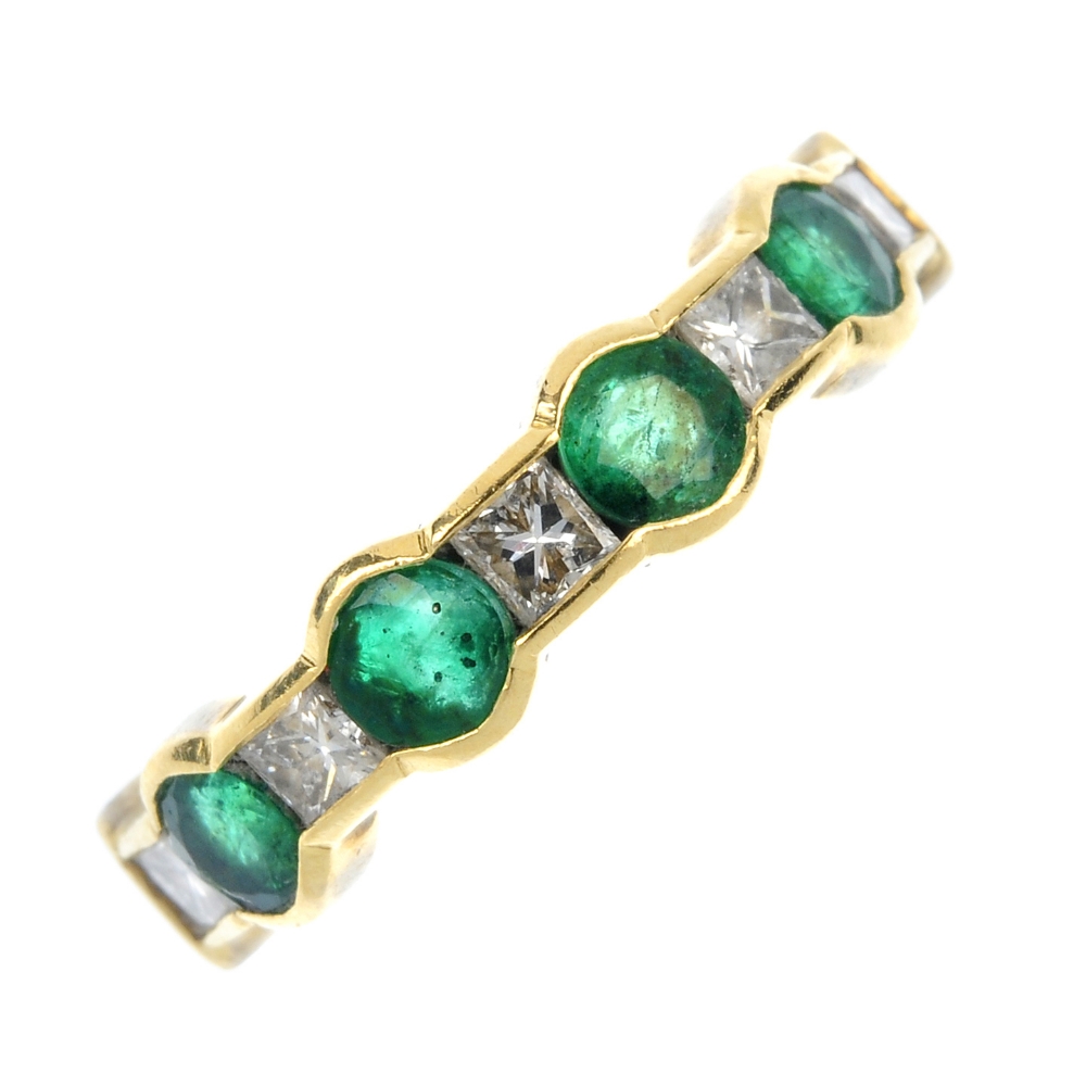 An 18ct gold emerald and diamond half-circle eternity ring. The alternating circular-shape emerald