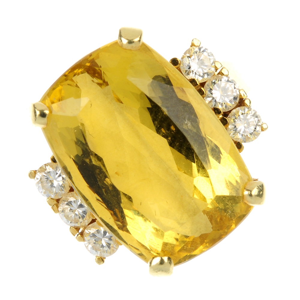 A beryl and diamond ring. The cushion-shape yellow beryl, with brilliant-cut diamond sides, to the