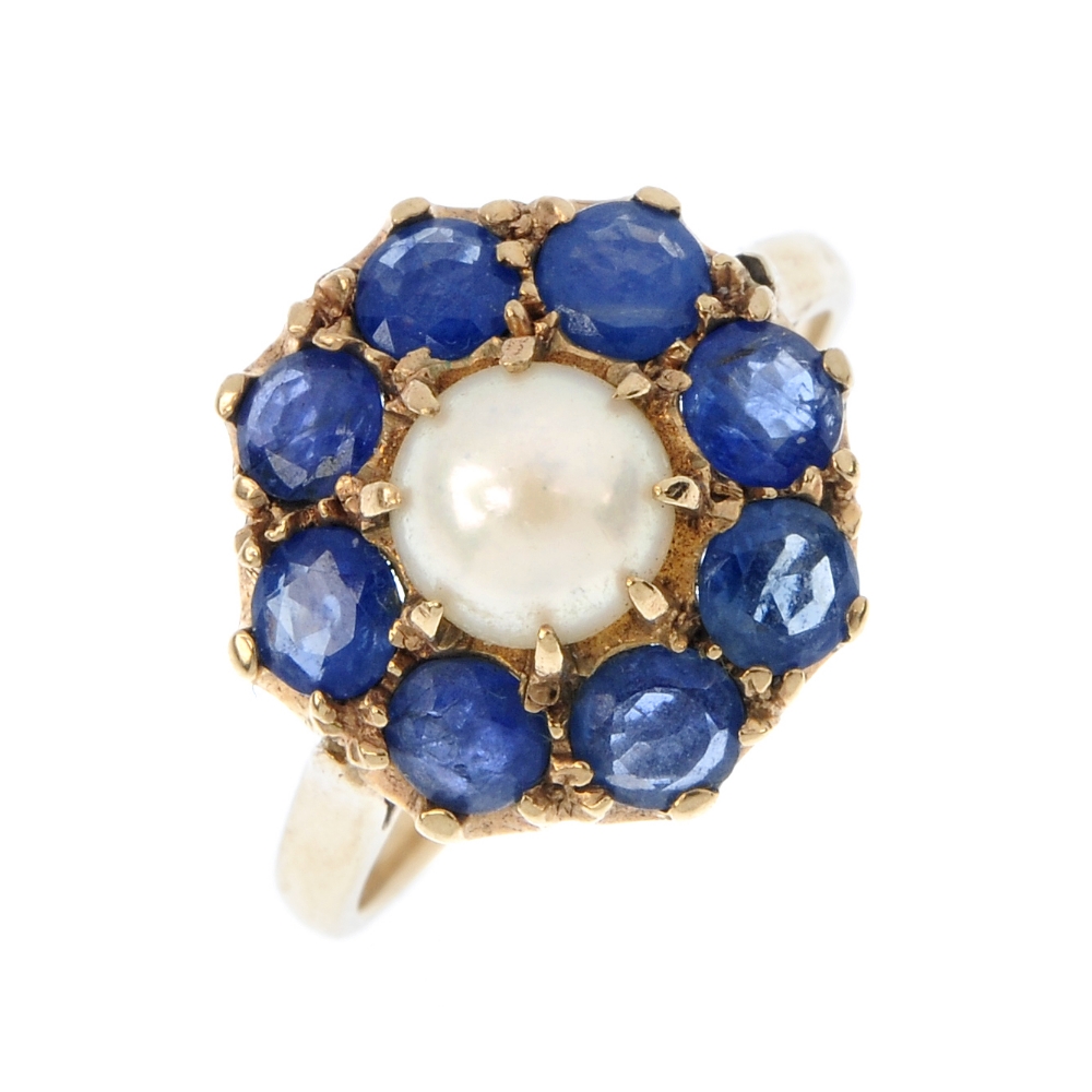 A sapphire and split pearl floral cluster ring. The split pearl, within a circular-shape sapphire