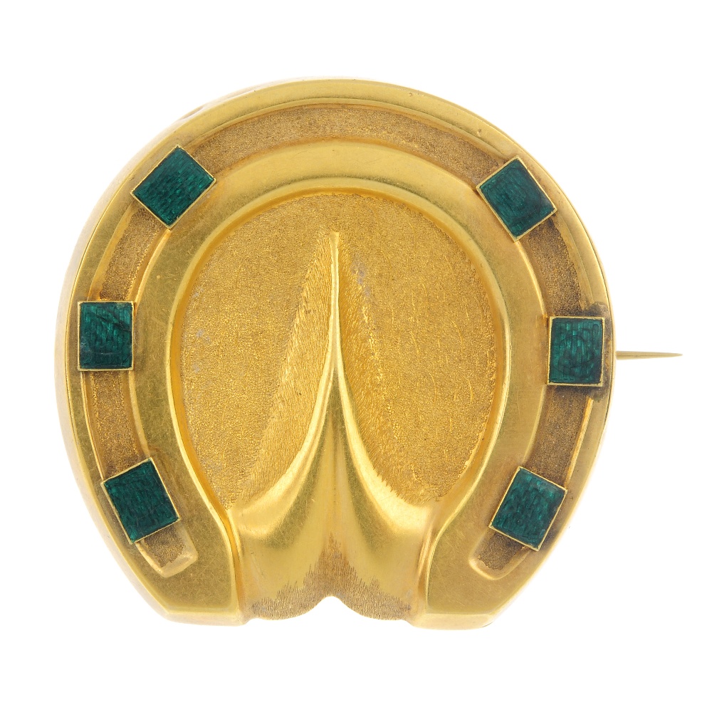 A late 19th century gold enamel memorial brooch. Designed as a textured horseshoe, with green