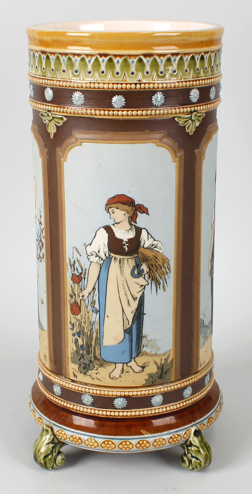 A large 19th century Mettlach pottery vase of cylindrical form, the brown glazed ground detailed