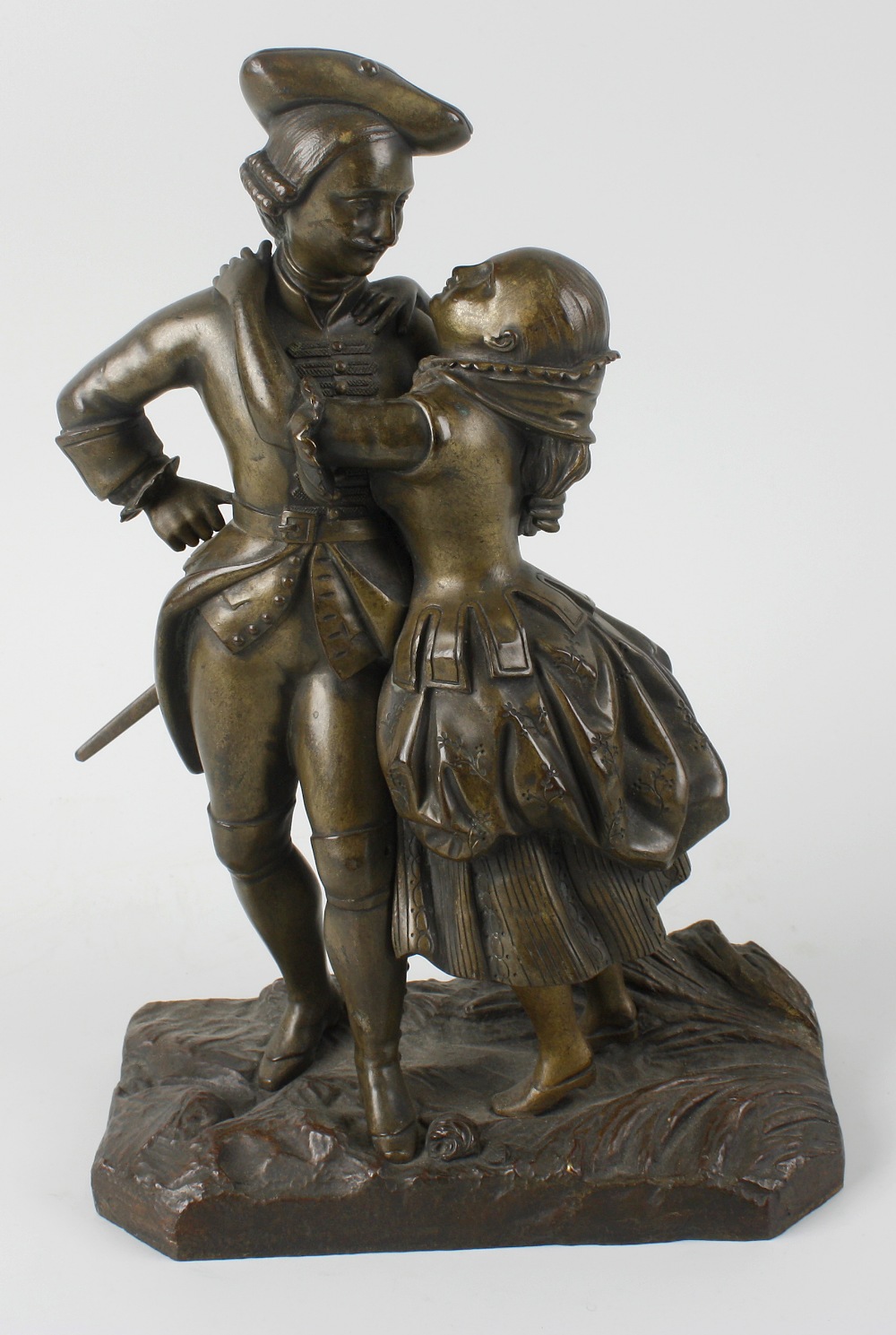 A late 19th century cast bronze figure group modelled as a dandy with a lady, he standing with hand