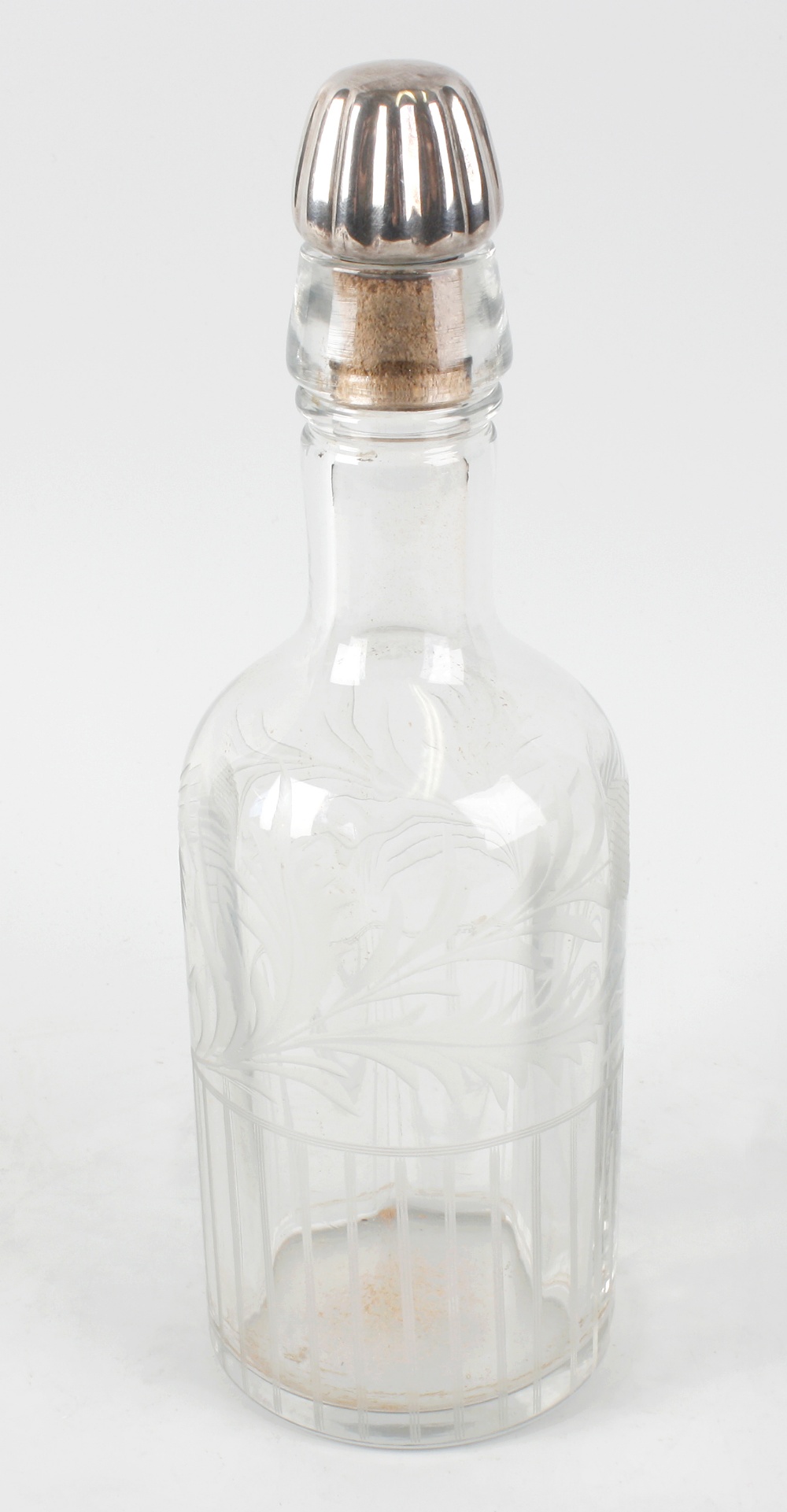 A Scottish engraved glass whisky bottle, the clear body etched with thistles, beneath a silvered