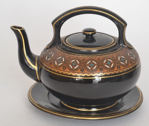 In the manner of Christopher Dresser - A late 19th Century Jackfield style teapot on stand, the