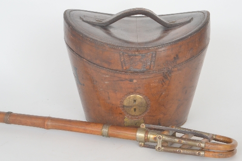 A late 19th Century leather top hat box with brass lock and red silk lined interior, together with