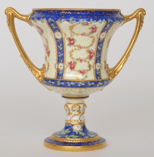 A Royal Crown Derby twin handled pedestal cup decorated with intertwined hand-painted roses and