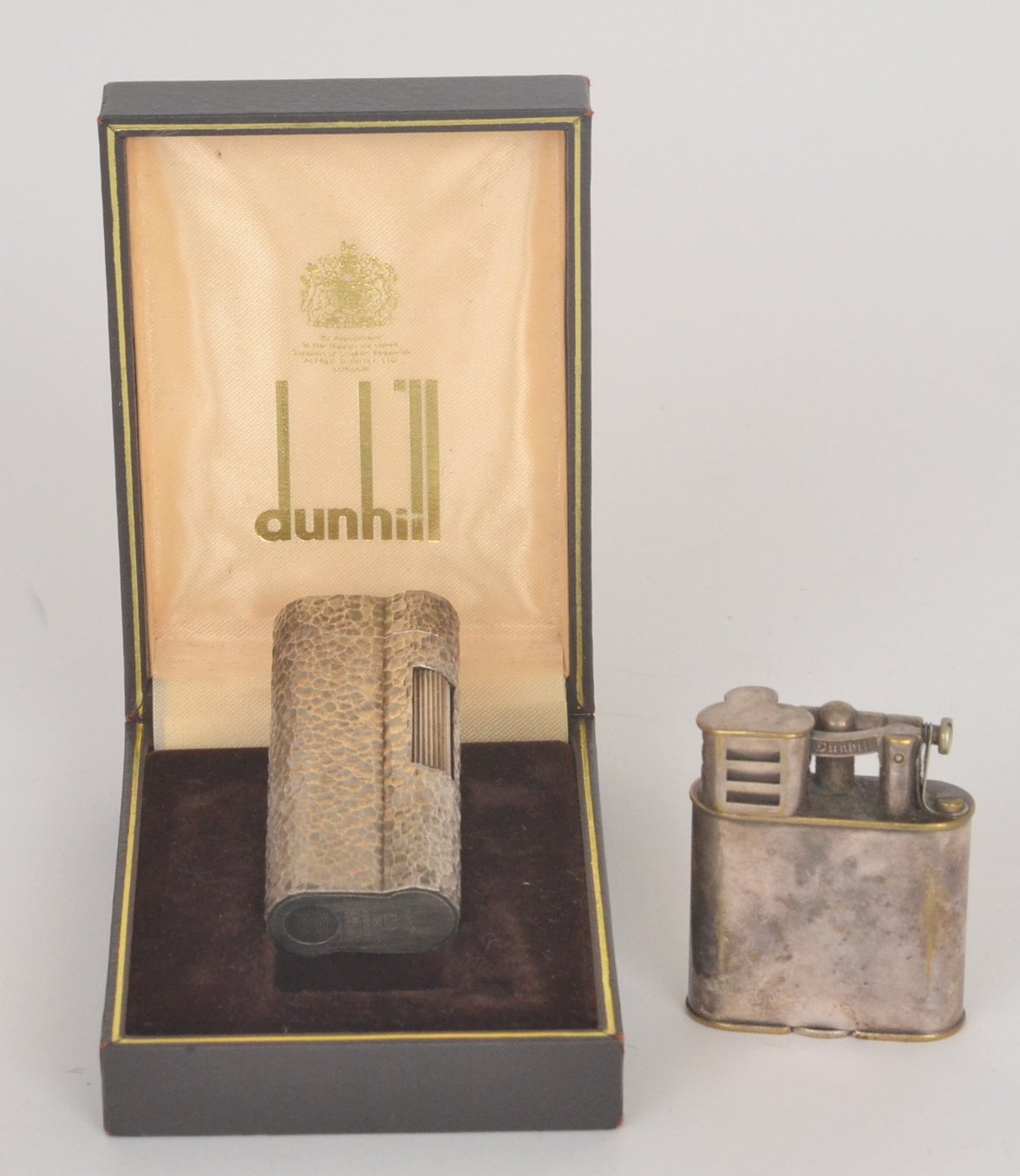 A 1970s Dunhill plated pocket lighter in bark effect case together with another by Dunhill (2)