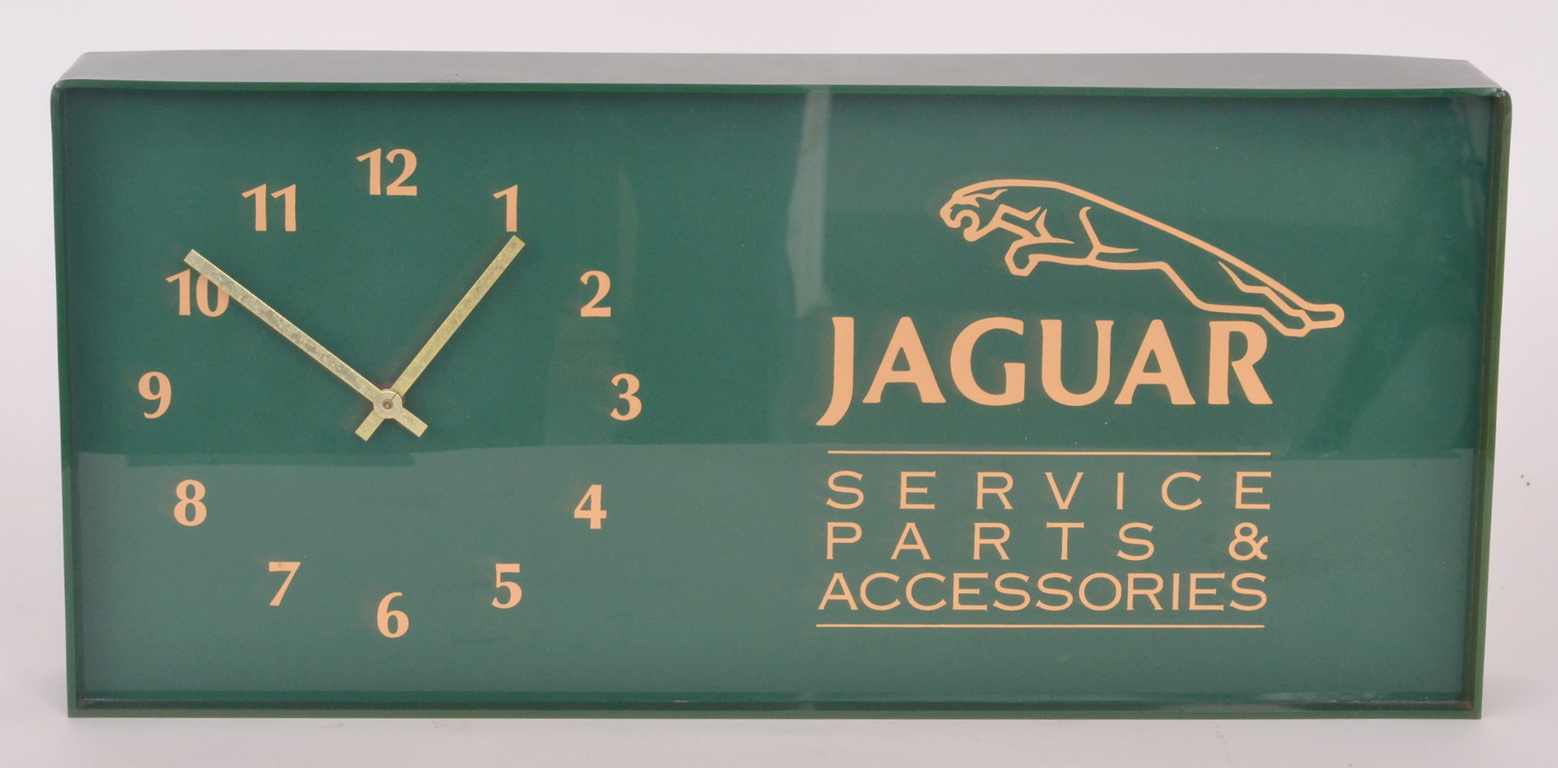 A post 1950s Jaguar rectangular green plastic wall clock for service parts and accessories, 23cm x