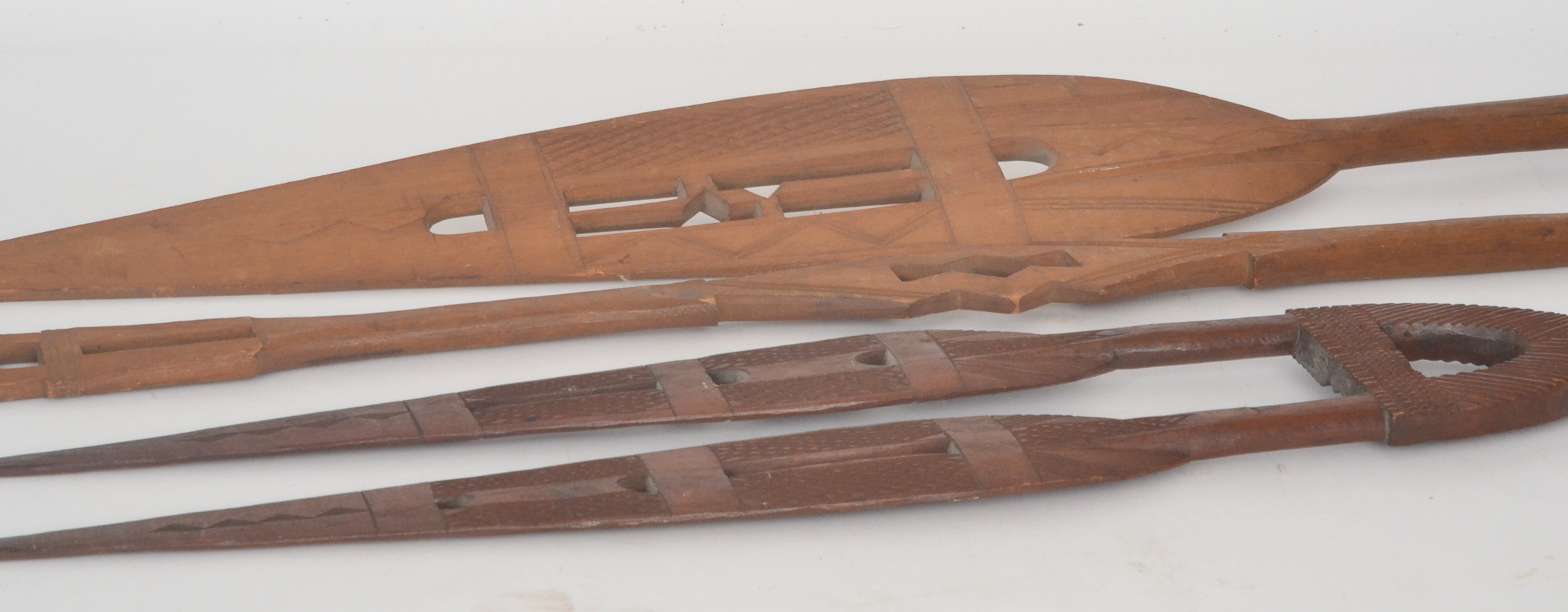 A near pair of African tribal hardwood ceremonial paddle spears, with elliptical pierced blades