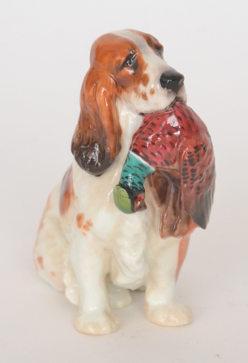 A Royal Doulton model of a brown and white Setter dog holding a pheasant to its mouth, HN1029