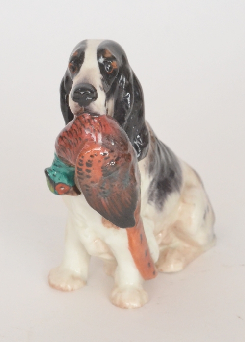 A Royal Doulton model of a black and white Setter dog holding a pheasant to its mouth, HN1062