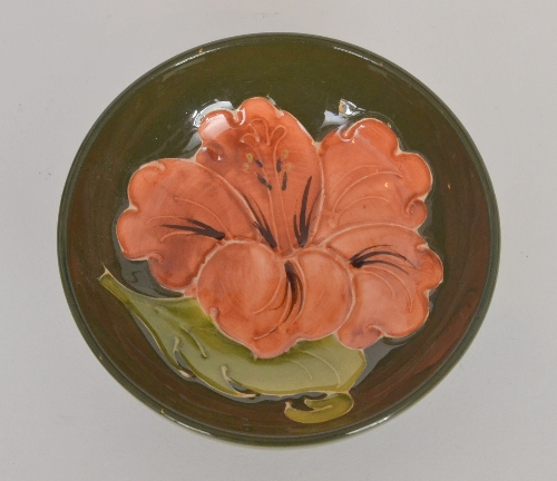 A Walter Moorcroft Coral Hibiscus shallow footed circular bowl decorated with a large stylised