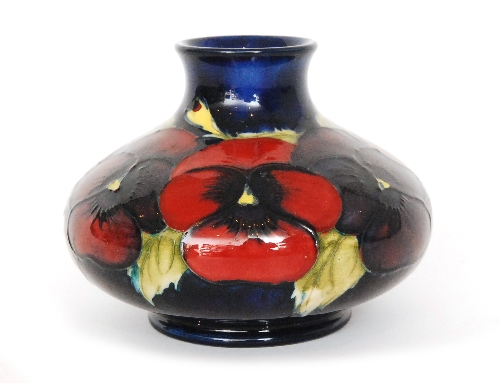 A Moorcroft vase of squat form decorated in the Pansy pattern with a central band of crimson and