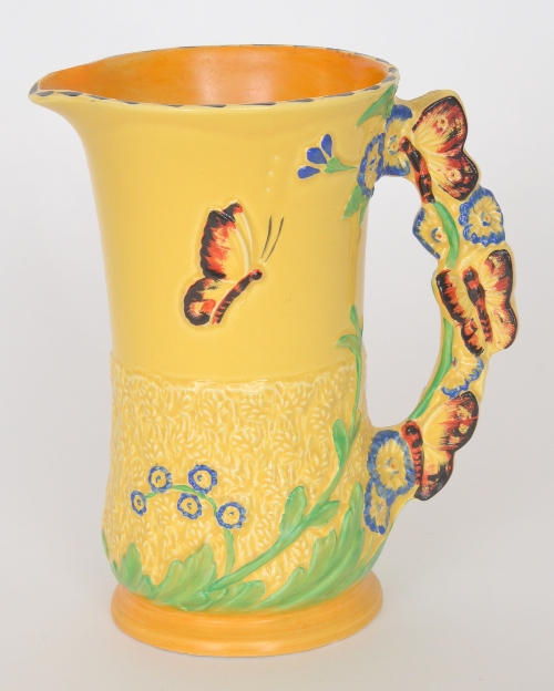 A 1930s Burleigh Ware jug, the body decorated with low relief butterfly and blue flower heads