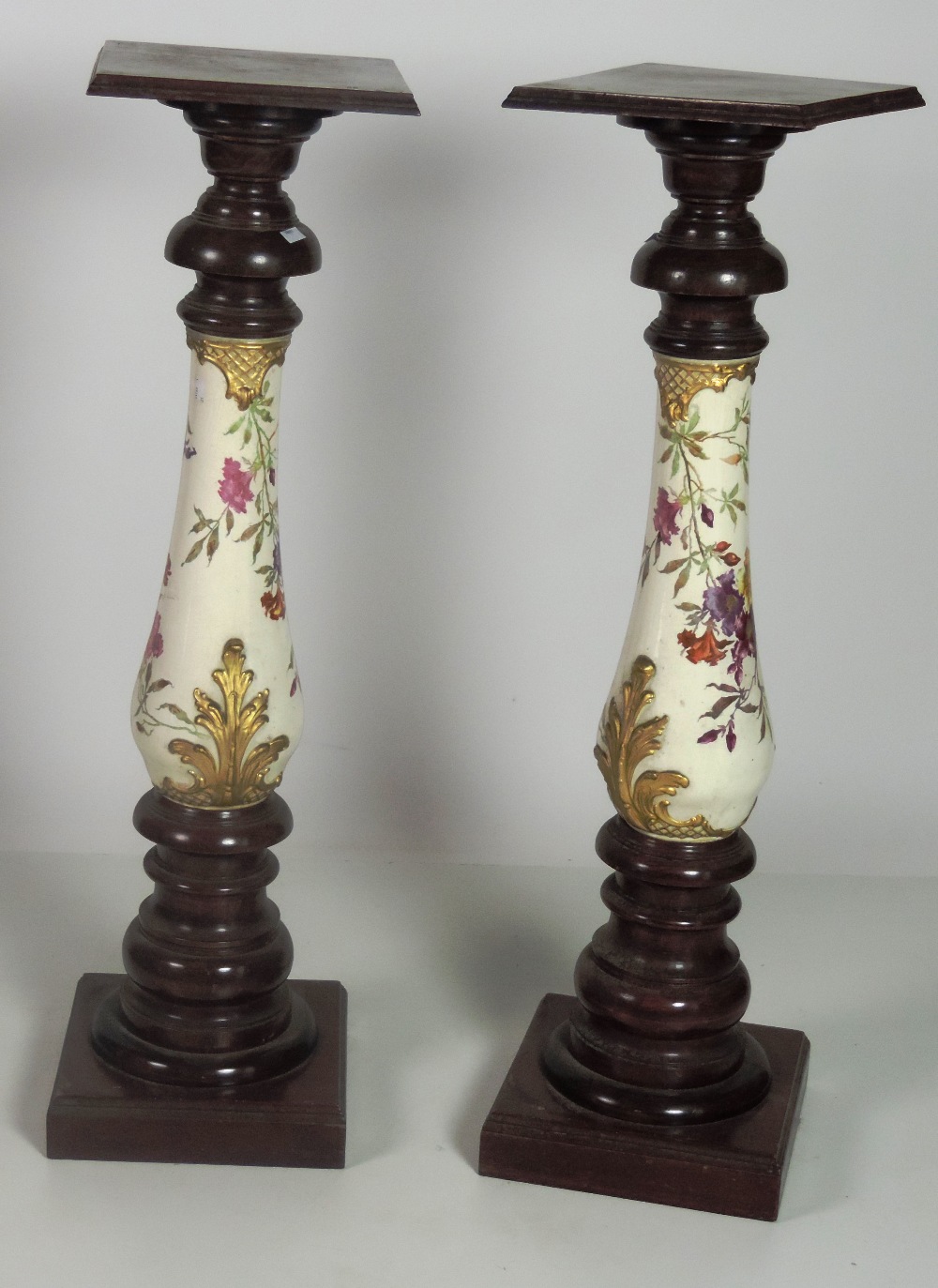 An unusual pair of tall porcelain and wooden Plinths, the pillars decorated with flowers, each