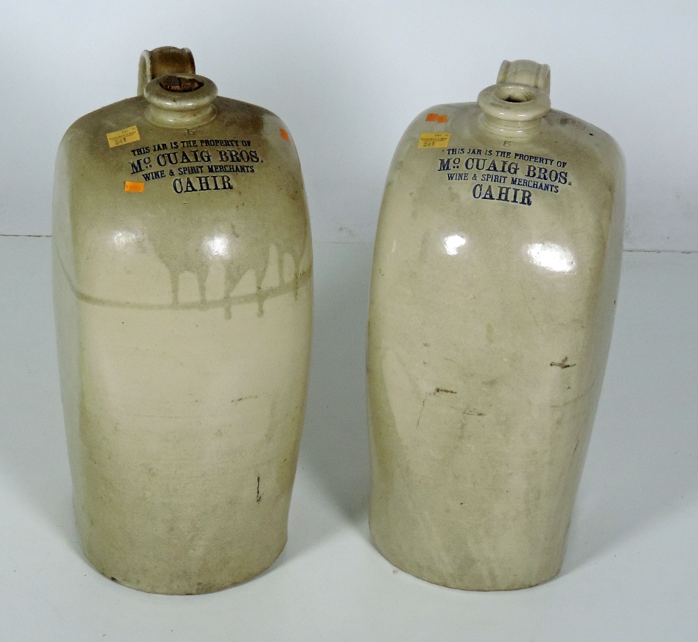 Two large earthenware Whiskey Jars, inscribed "Mc Cuaig Bros. Wine & Spirit Merchants, Cahir," 53cms