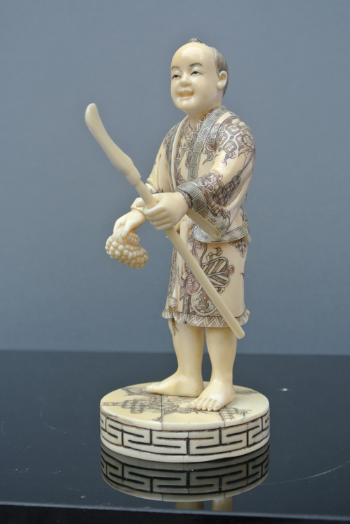 Japan School 19th century. An interesting carved and polychrome ivory sculpture of a woman and a