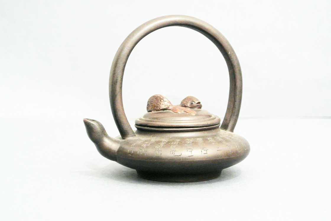 Chinese School 19th century. A fine Yixin terracotta teapot, with a lid decorated with fish in