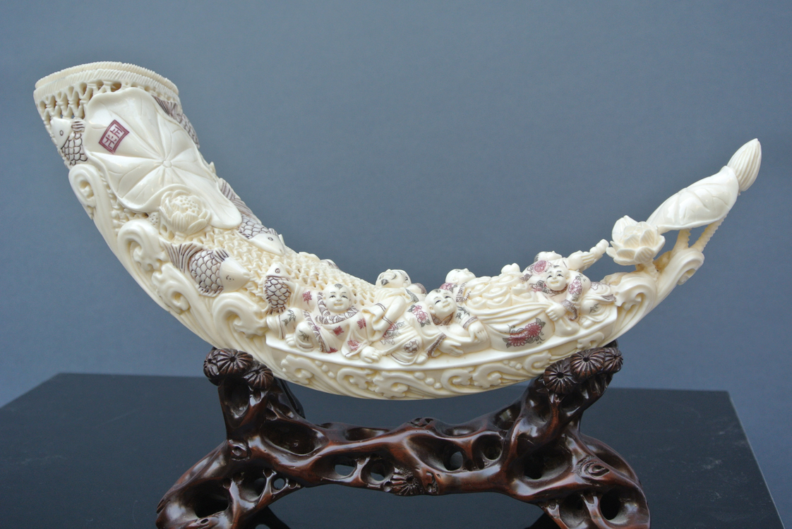 Japan School 19th century. A striking carved and pierced ivory tusk depicting men, fish and flowers