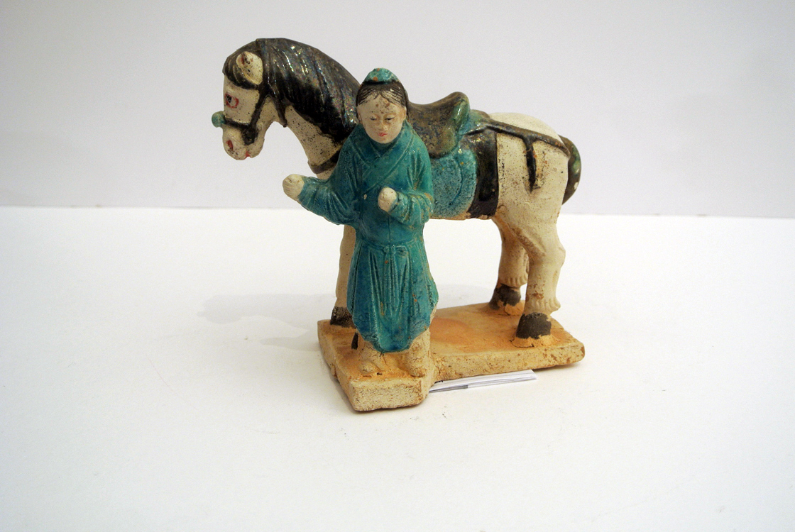 China Tang Dynasty. A polychrome terracotta sculpture depicting a `dignitary with his horse`, China