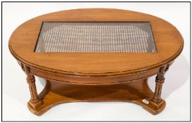 Walnut Covered Oval Shaped Coffee Table, glazed rattan centre on reeded scrolling arms & wings.