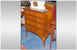 Edwardian Walnut Chest with four graduated drawers and a top shaped pediment. Terminating on small