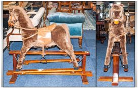 A Fabric Covered Rocking Horse with a felt mane and tail. With a leatherette seat and reins. On a