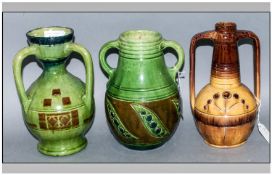 Three Various Belgian Majolica Vases comprising a green lustre, three handled, baluster vase with